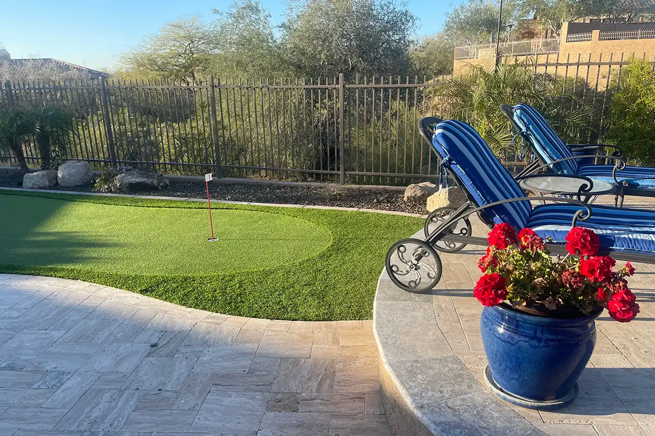 Backyard putting green with patio seating and potted flowers